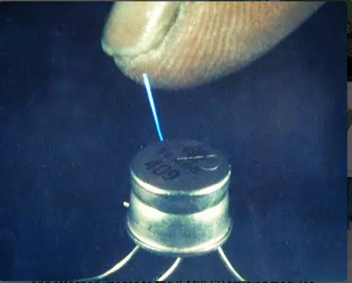 A blue spark jumping from a fingertip to the metal can of a transistor