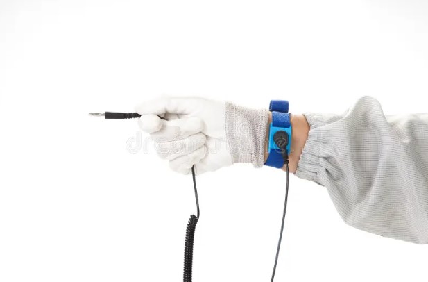 Gloved hand wearing a grounded ESD wrist strap with coiled cord